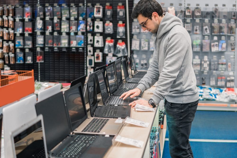 Smart,Modern,Male,Customer,Choosing,Laptop,In,The,Computer,Shop.